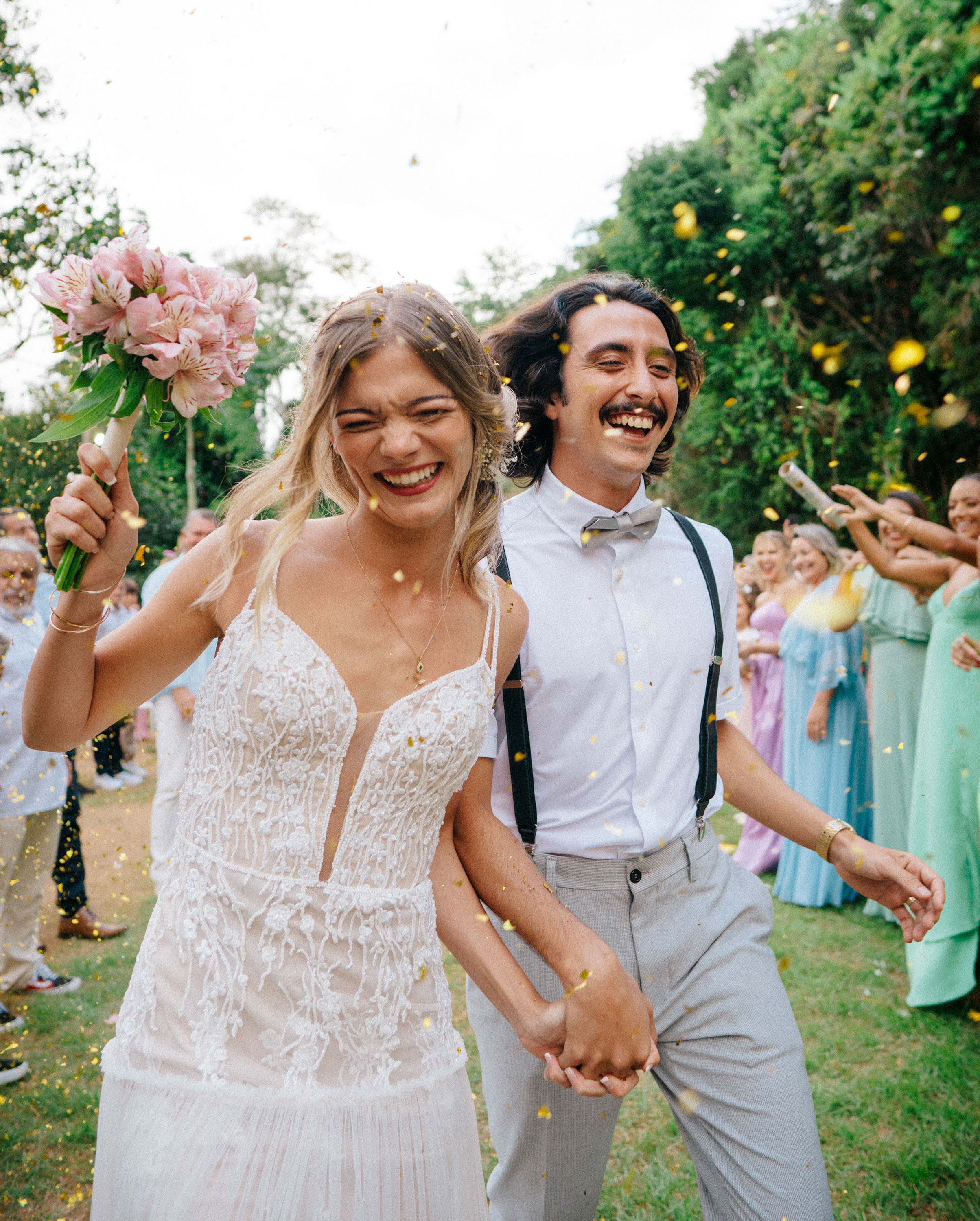 Noivos rindo sob chuva de confete — casamento documental ao ar livre