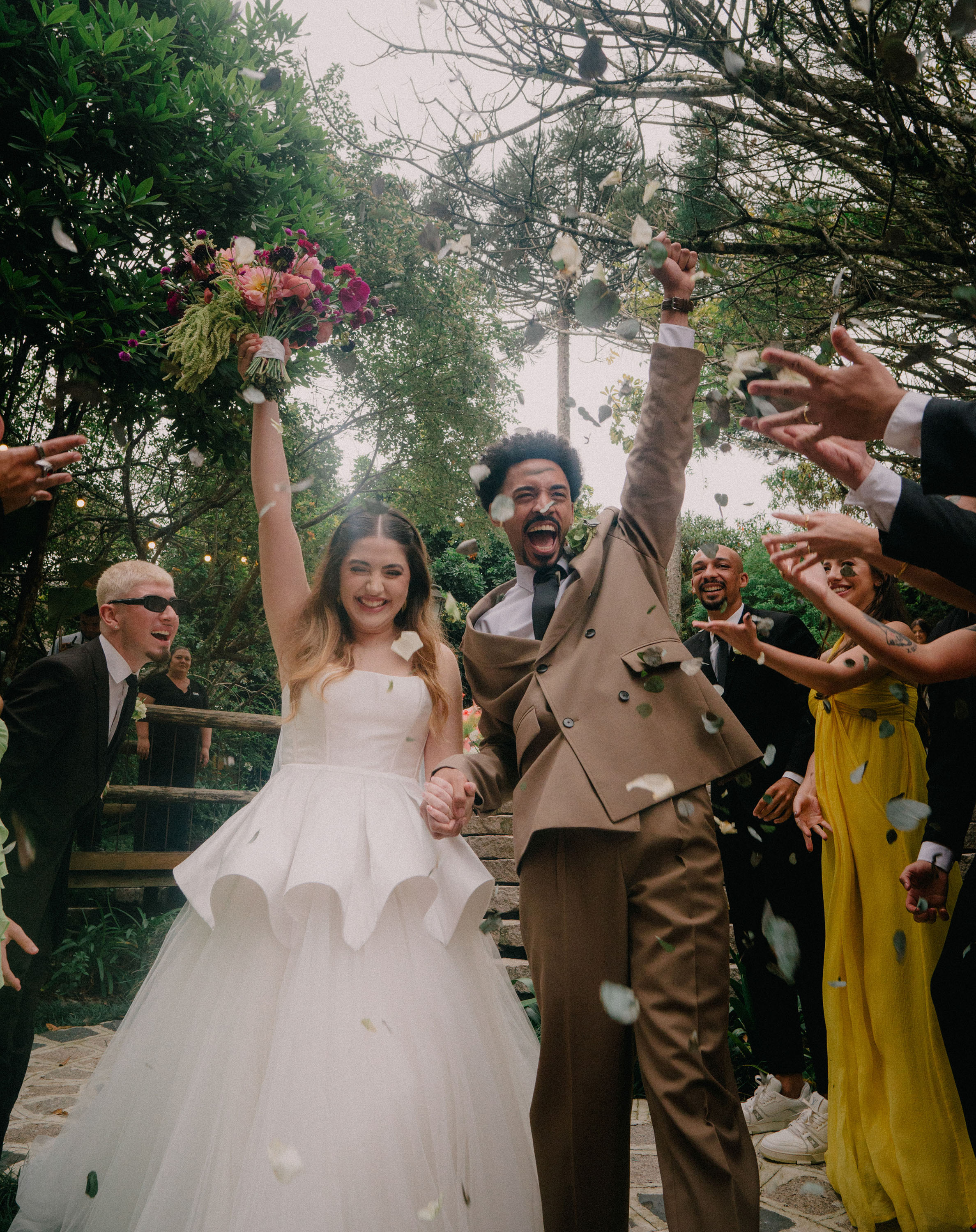 Casal celebrando com pétalas após cerimônia — casamento no campo