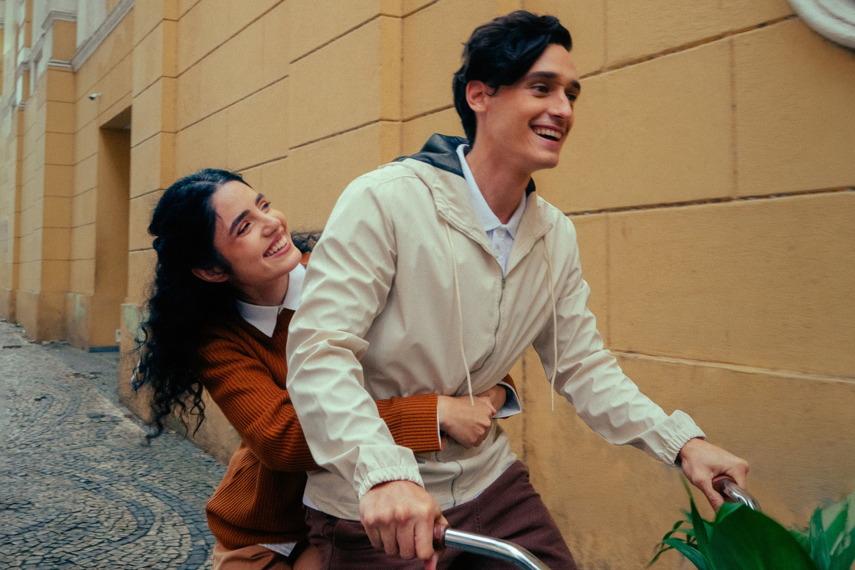 Casal em bicicleta por rua de paralelepípedo — ensaio pré-wedding urbano