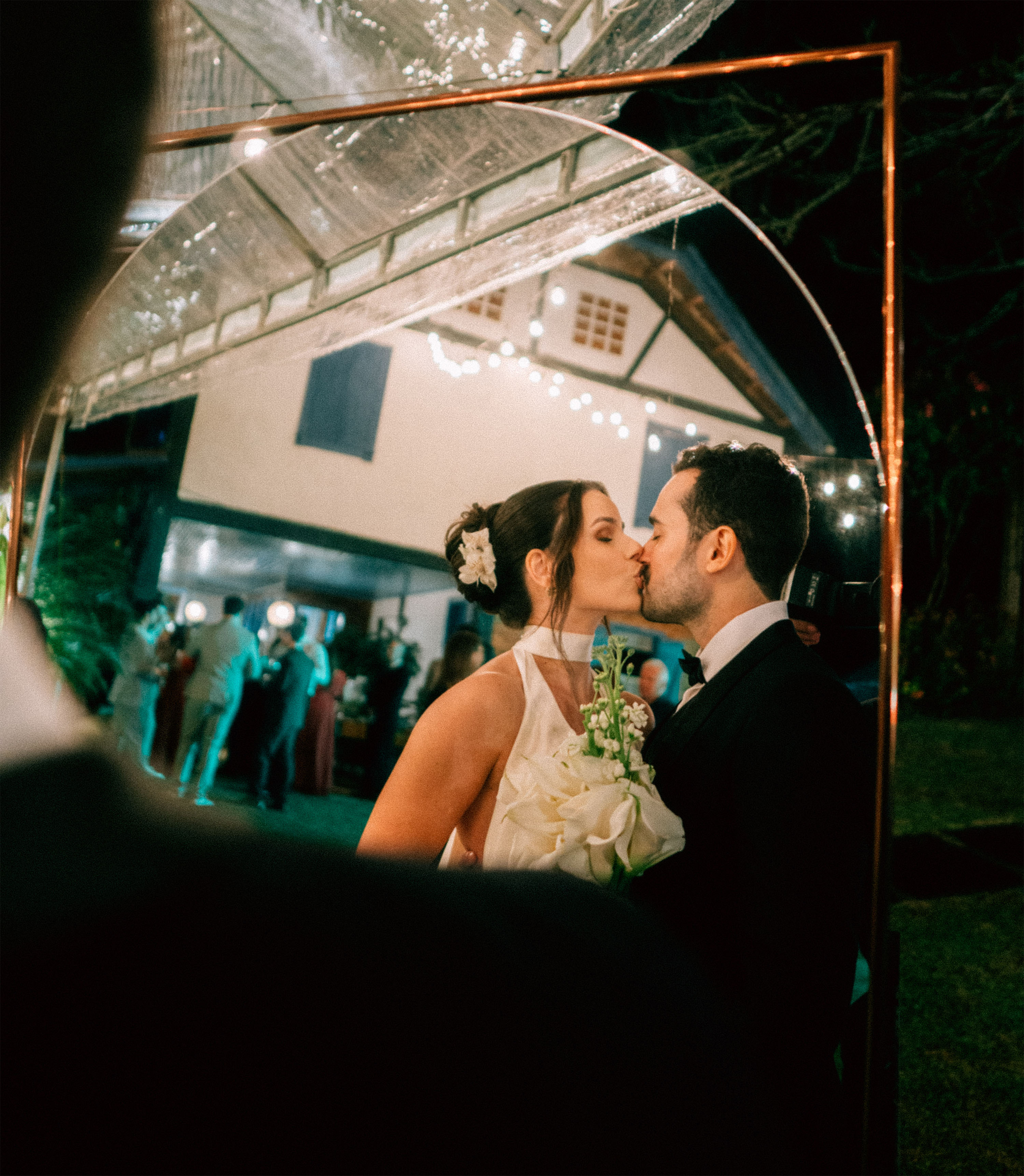 Primeiro beijo dos noivos enquadrado na festa